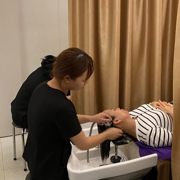 Kỹ thuật viên đang thực hiện gội đầu dưỡng sinh