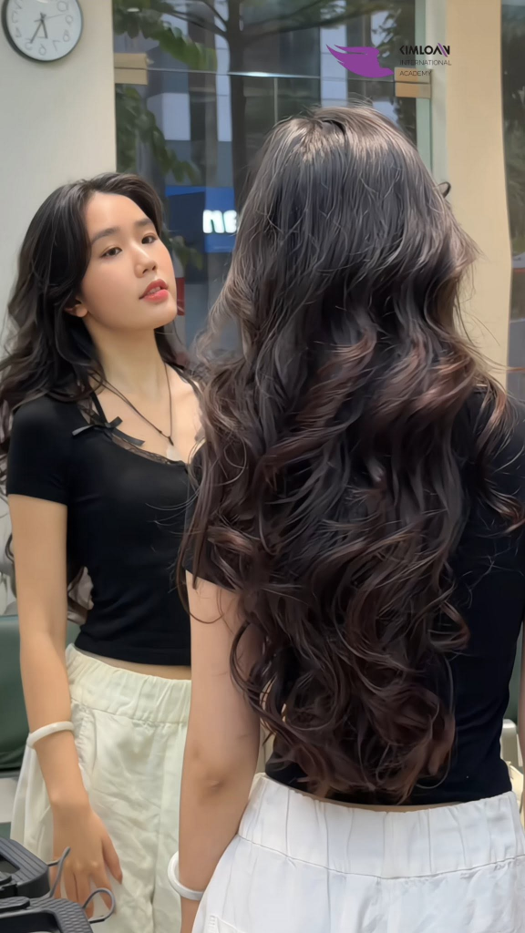 Tóc Dài Uốn Xoăn Bung Lơi: Kiểu Tóc Mềm Mại, Cuốn Hút Và Đầy Chuyển Động Tại Kim Loan Hair Salon 2 Phom tóc xoăn bung lơi nhìn từ phía sau và hình ảnh phản chiếu trước gương