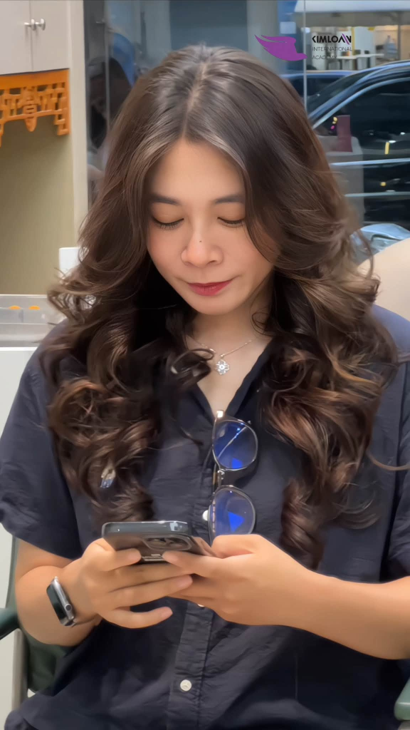 Khách hàng cúi đầu sử dụng điện thoại thể hiện phom tóc bồng bềnh